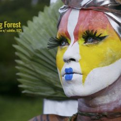 Uyra: The Rising Forest - poster - Image of a person with face paint in red, yellow, white, and blue colors