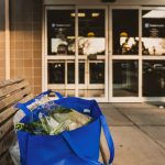 Blue tote bag with fresh veggies in it.
